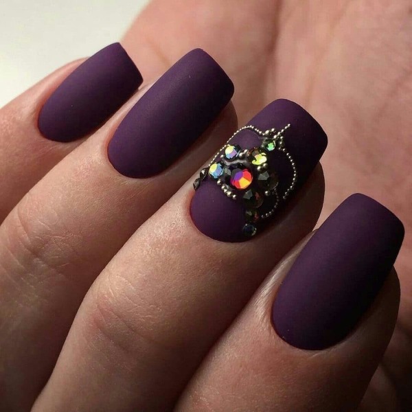 Conception d'ongle violet. Photo avec une image, des strass, des étincelles, des frottements