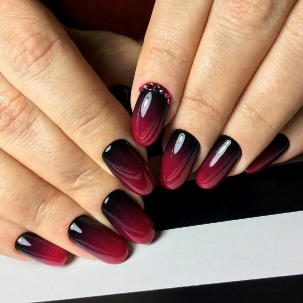 Stylizacja paznokci w ciemnych kolorach i odcieniach. Zdjęcie manicure z cyrkoniami, błyskami, french na krótkie, długie paznokcie