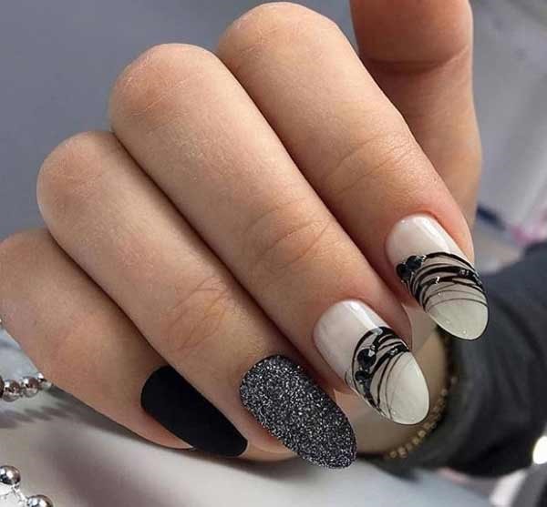 Conception d'ongles en noir et blanc. Photo de nouveaux articles avec strass, argent, veste de service, or, motif