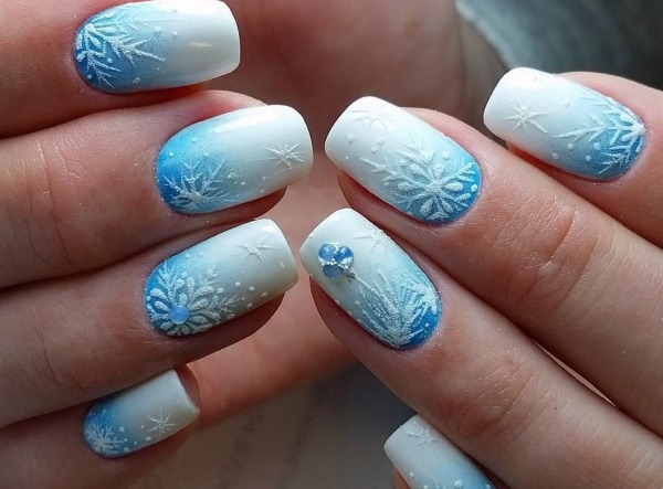 Dessins d'ongles en bleu. Photo de manucure avec strass, paillettes, motifs, frottements, français