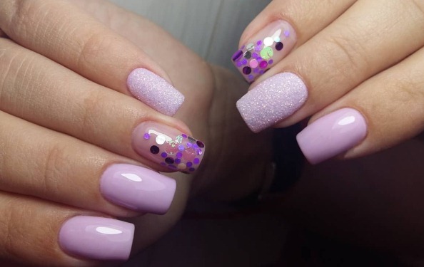 Conception des ongles dans les tons violets. Photo avec strass, fleurs, étincelles, pierres, bouillons, frotter