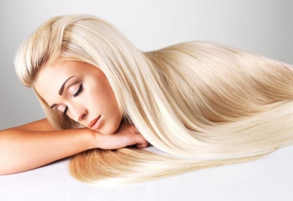 La beauté et la santé des cheveux longs chez les blondes. Prendre soin des boucles en été et en hiver à la maison, photo