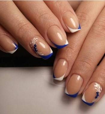 Conception d'ongles bleus avec vernis gel blanc. Photo française, avec strass, argent