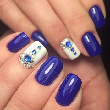 Conception d'ongles bleus avec vernis gel blanc. Photo française, avec strass, argent
