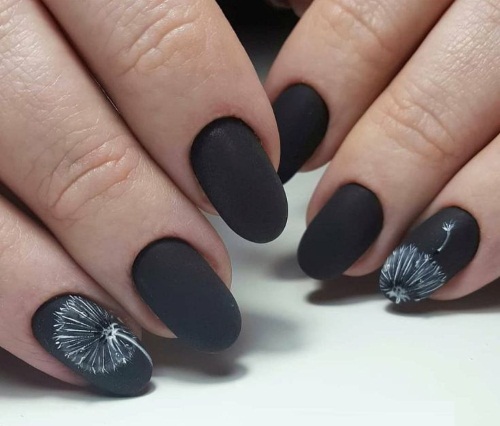 Manucure noire mate avec des dessins pour ongles longs et courts. Une photo