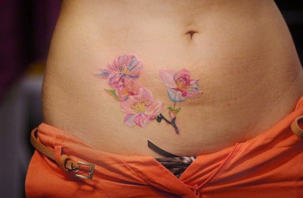 Tatouage du ventre pour les filles. Photos, croquis de fleurs, inscriptions, animaux, motifs