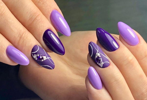 Conception des ongles lilas. Photo avec strass, violet avec des fleurs, motif