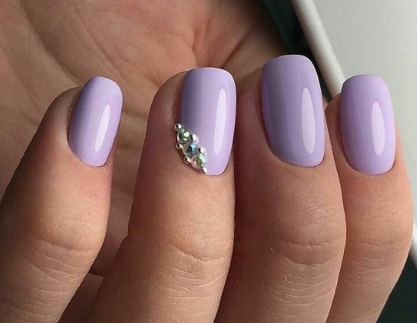 Conception des ongles lilas. Photo avec strass, violet avec des fleurs, motif